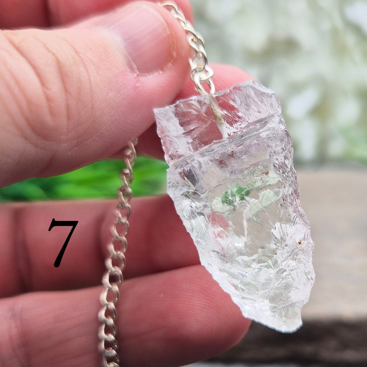 This Rock Quartz Crystal Pendulum from Brazil features a natural quartz crystal and a white bead at the end of the chain.