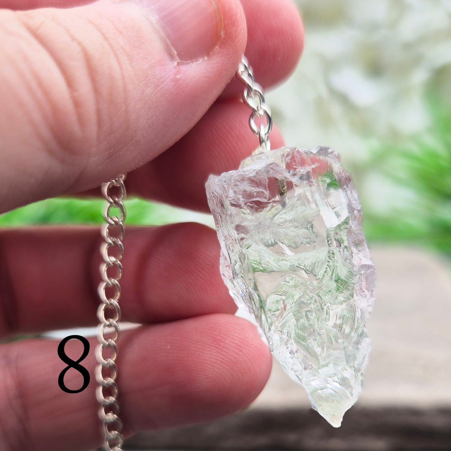 This Rock Quartz Crystal Pendulum from Brazil features a natural quartz crystal and a white bead at the end of the chain.