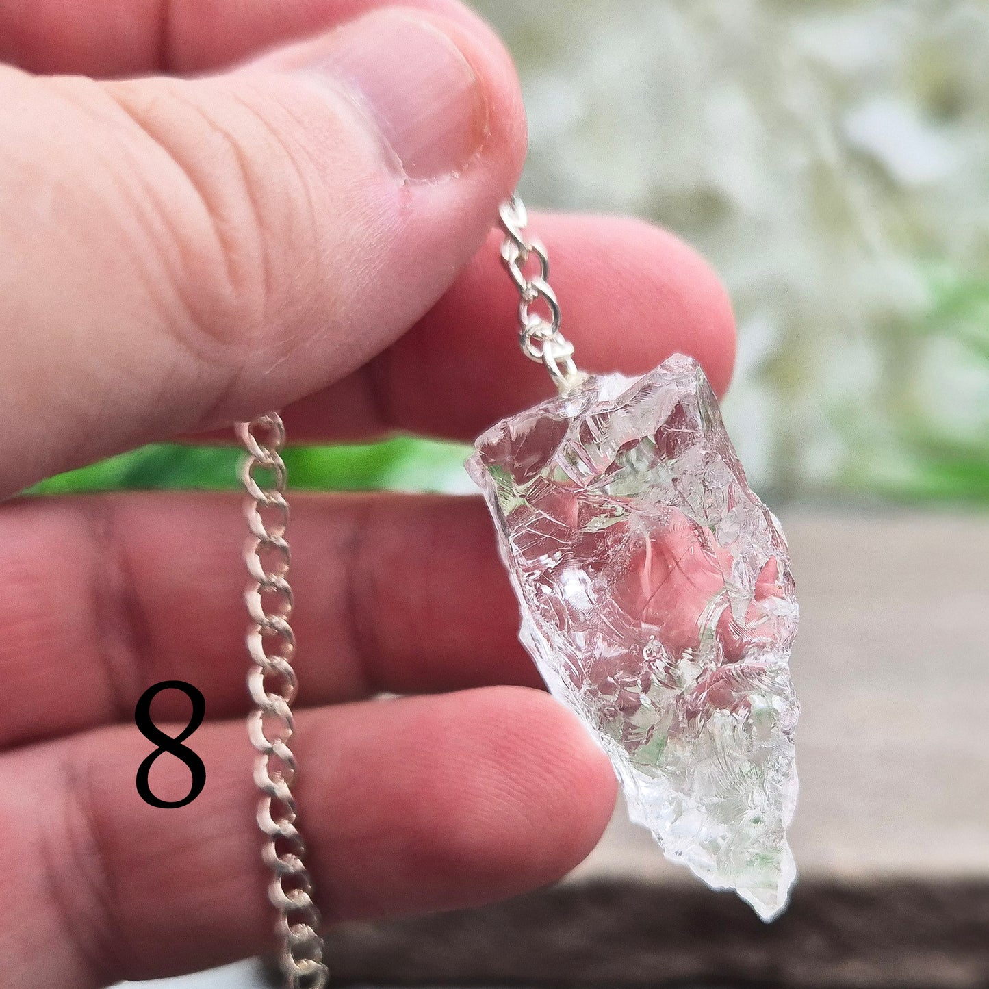 This Rock Quartz Crystal Pendulum from Brazil features a natural quartz crystal and a white bead at the end of the chain.