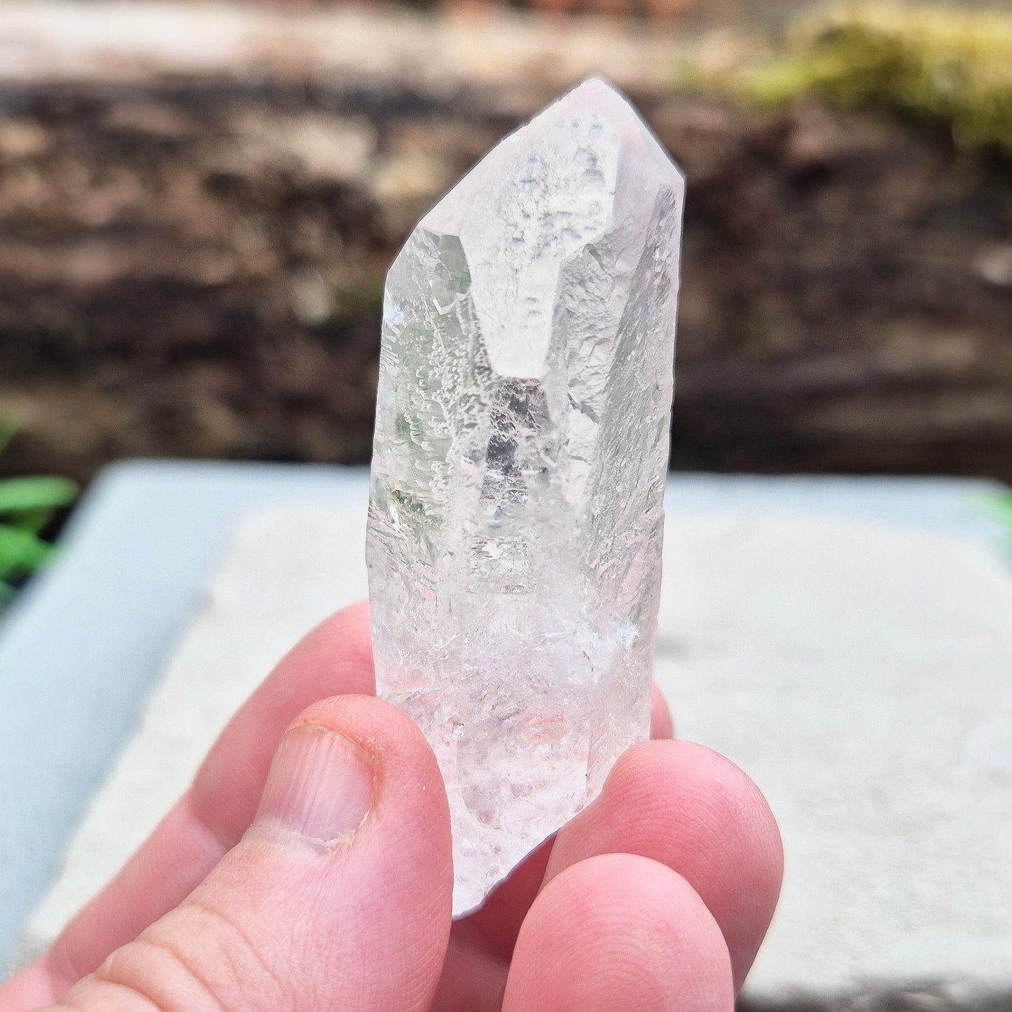 This natural quartz point has lovely clarity with Starbrary markings on at least two sides. These etched shapes — triangles, lines, and patterns — look like ancient writing and are thought to carry cosmic knowledge.