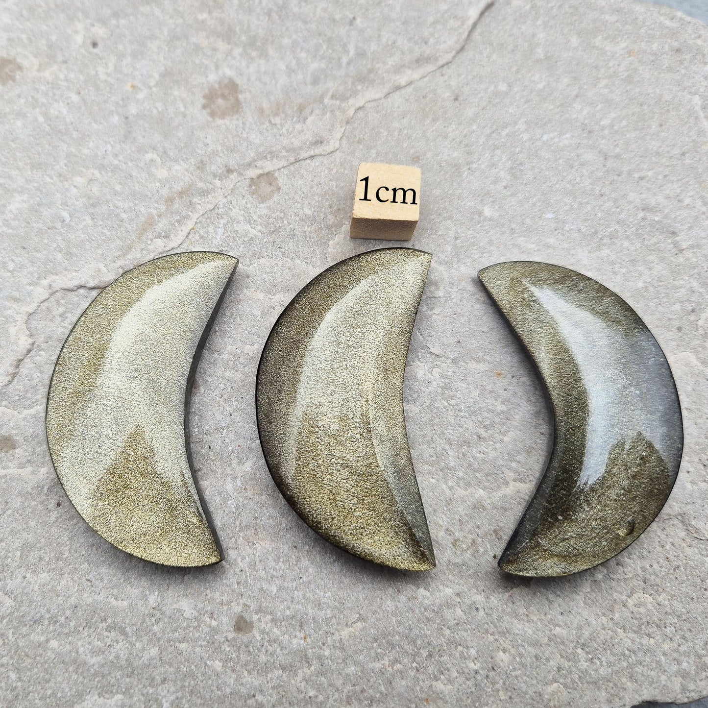 Gold Sheen Obsidian crescent moons from Mexico. Protective and empowering crystals that reveal truth, clear energy, and attract confidence and prosperity.