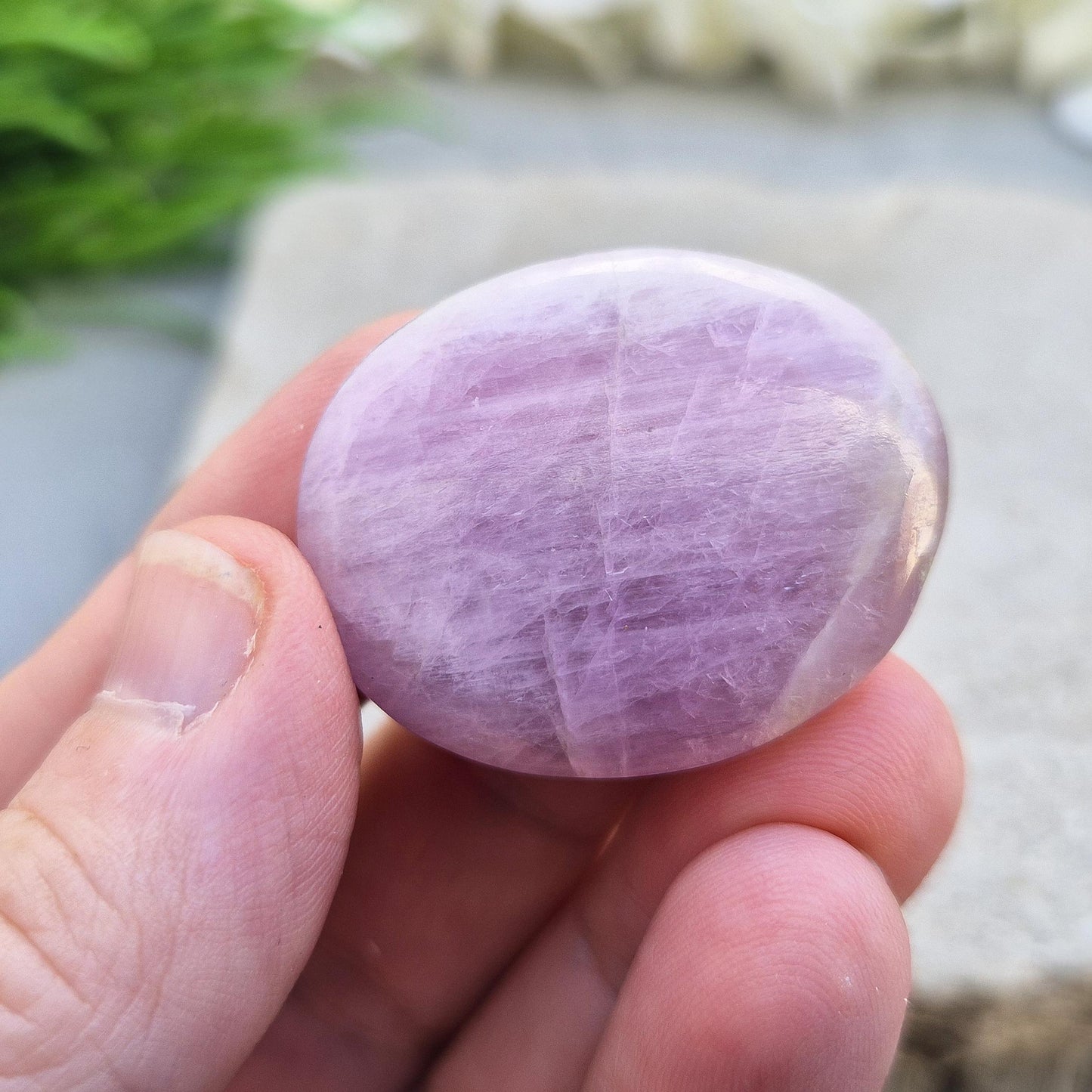 Polished lilac Kunzite palm stone. High-vibration crystal that calms the mind, opens the heart, protects the aura, and supports meditation.