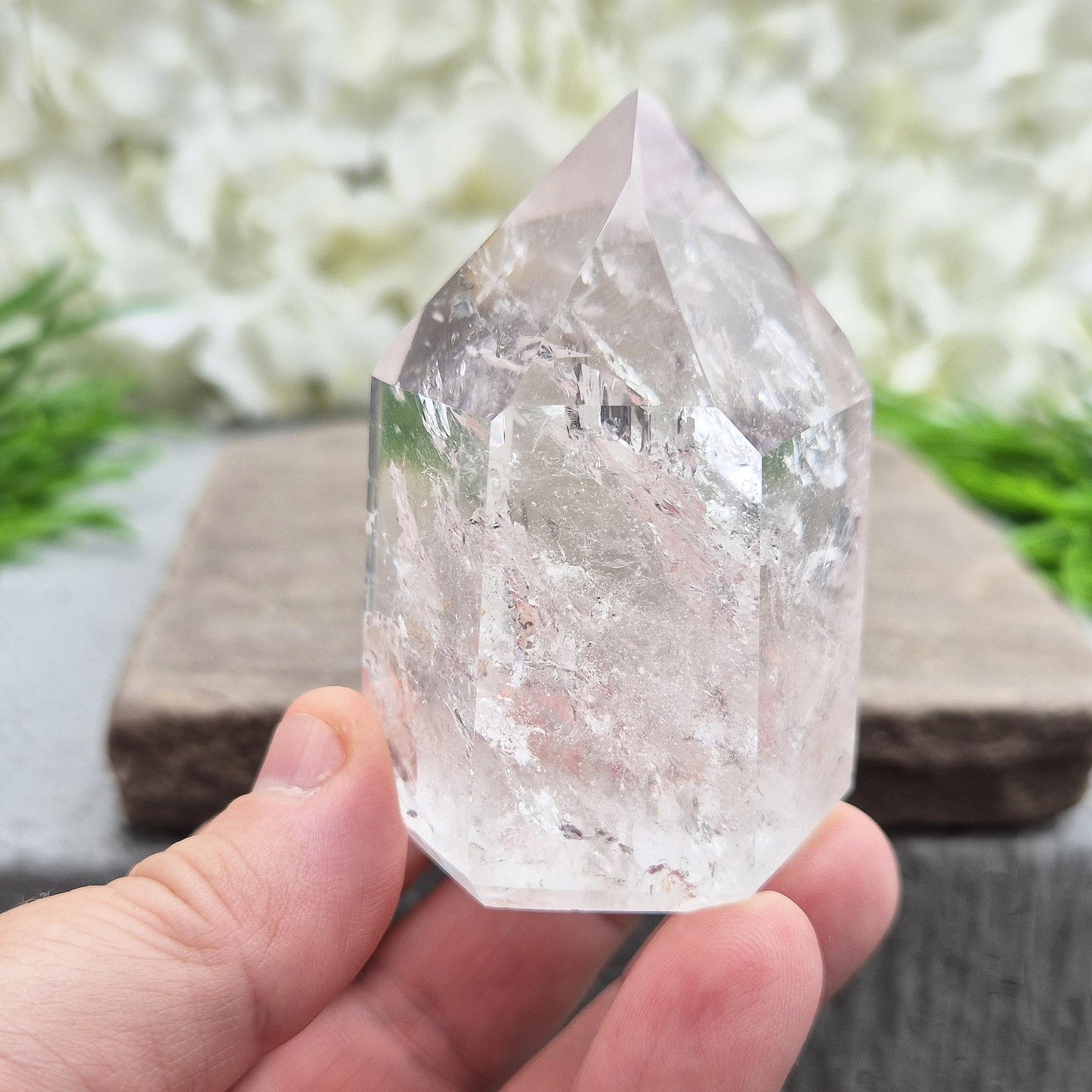 Polished Clear Quartz point from Brazil with sparkling inclusions. High vibration, versatile energy—perfect for clarity, healing, and spiritual focus.