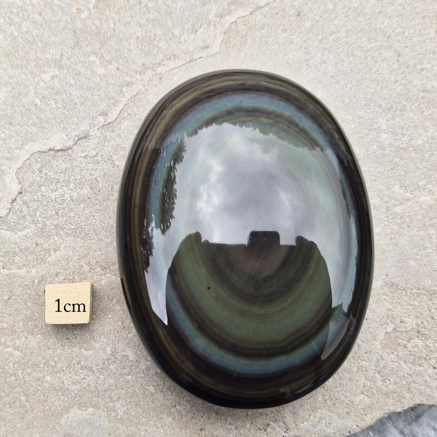 Rainbow Obsidian palmstone with green and gold bands — for gentle heart healing, grounding, and emotional release without overwhelm.