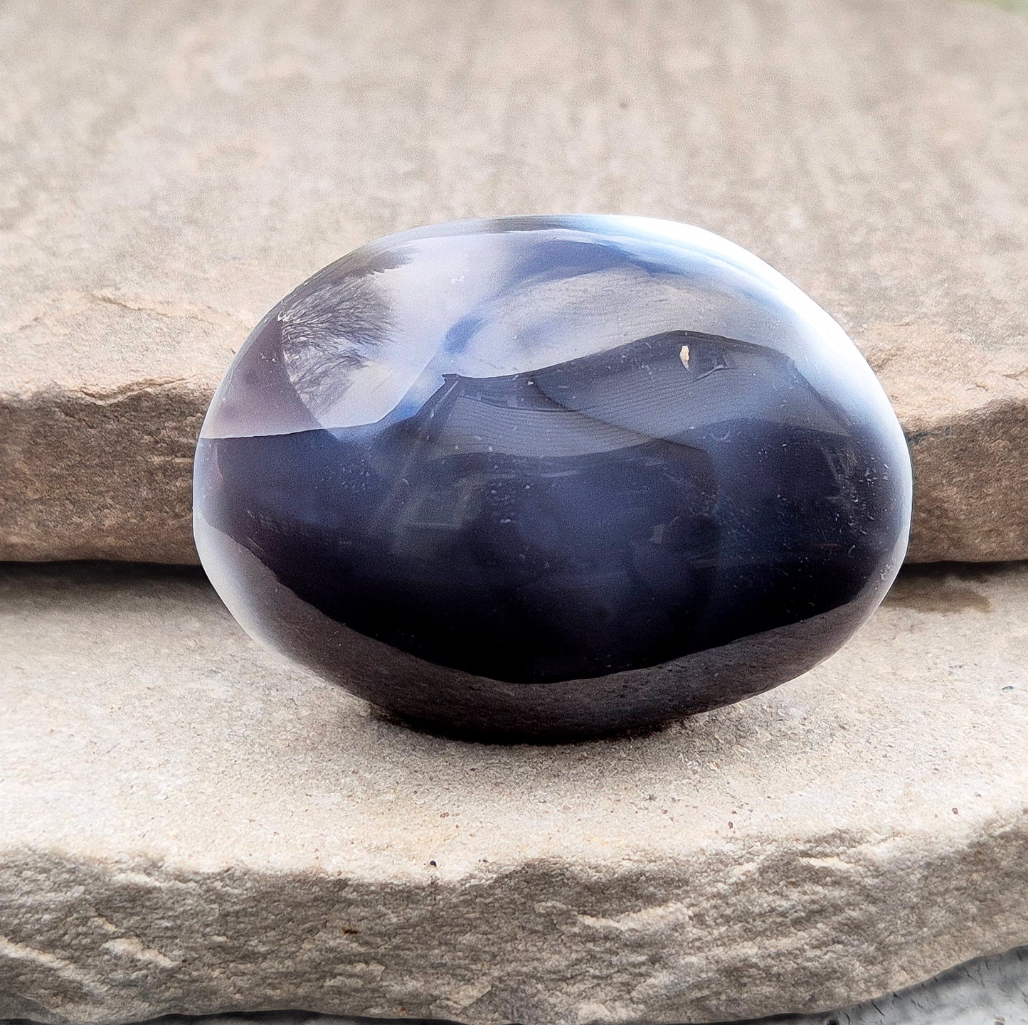 Polished Orca Agate (Grey Agate) galet with soft grey, white, and charcoal banding. A calming stone often chosen for emotional balance, grounding, and steady support.
