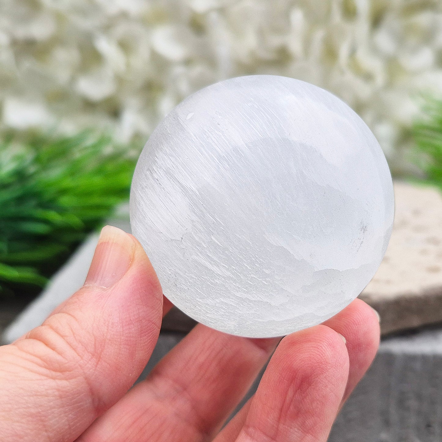 Selenite crystal ball with a soft, luminous glow. Ideal for cleansing energy, creating a peaceful atmosphere, and displaying as a calming centrepiece.
