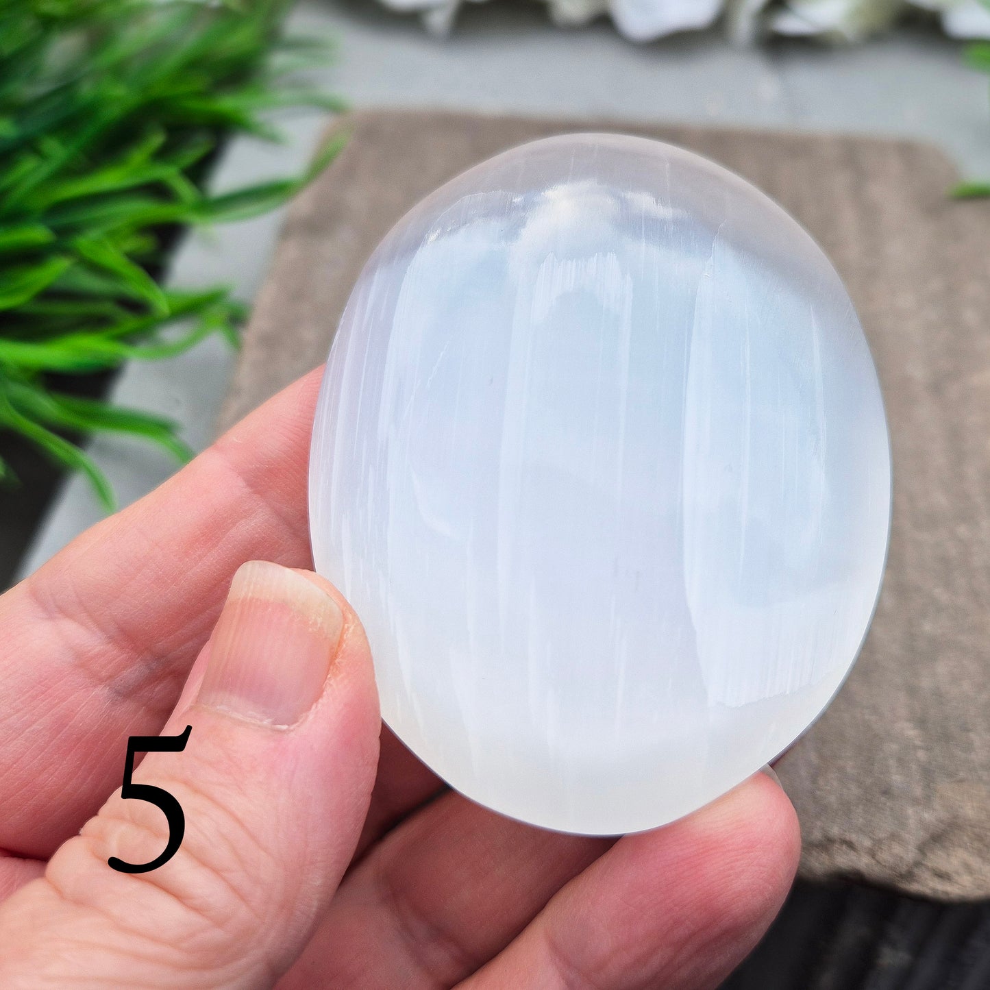Smooth selenite palm stone for calming your energy, soothing busy thoughts, and cleansing other crystals. A peaceful stone to hold during rest or reflection.