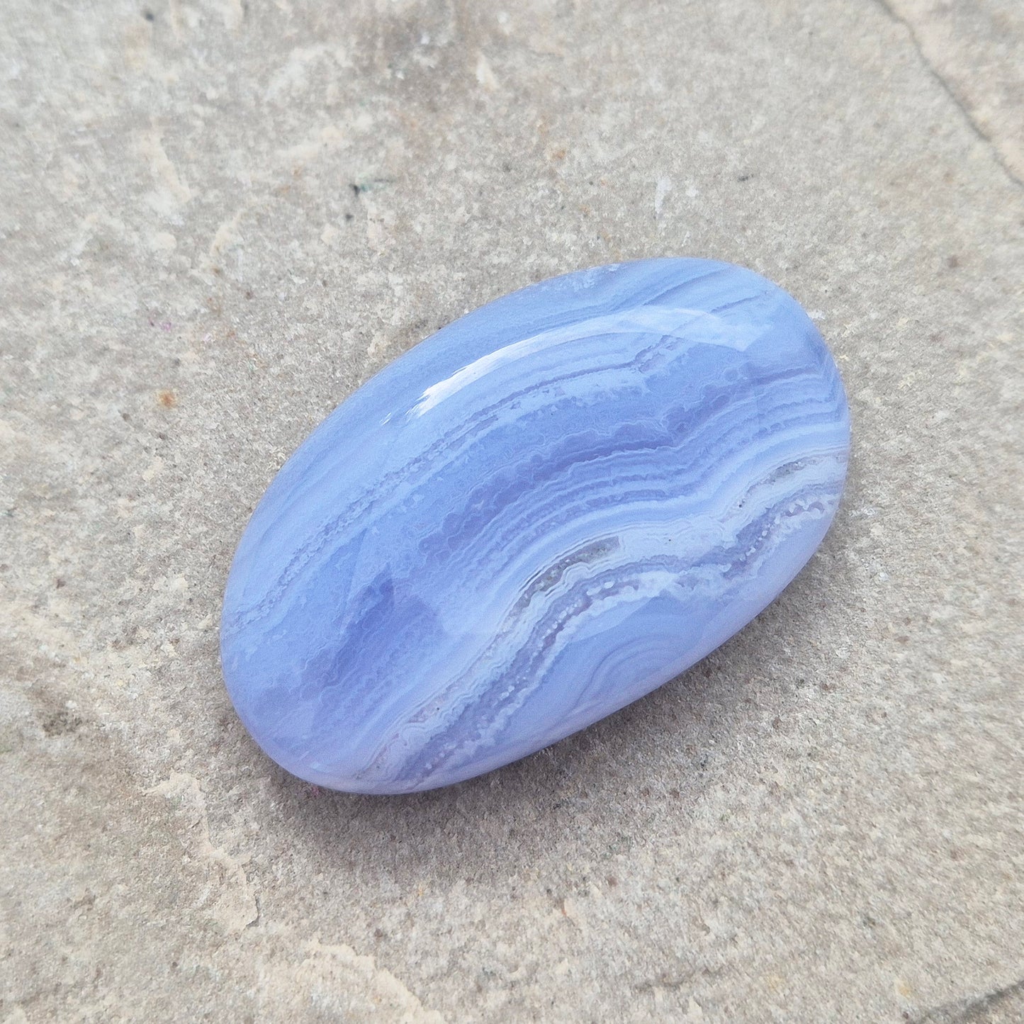 Polished Blue Lace Agate crystal palm stone with wonderful banding. A calming crystal, ideal for relaxation, clear communication and gentle healing.