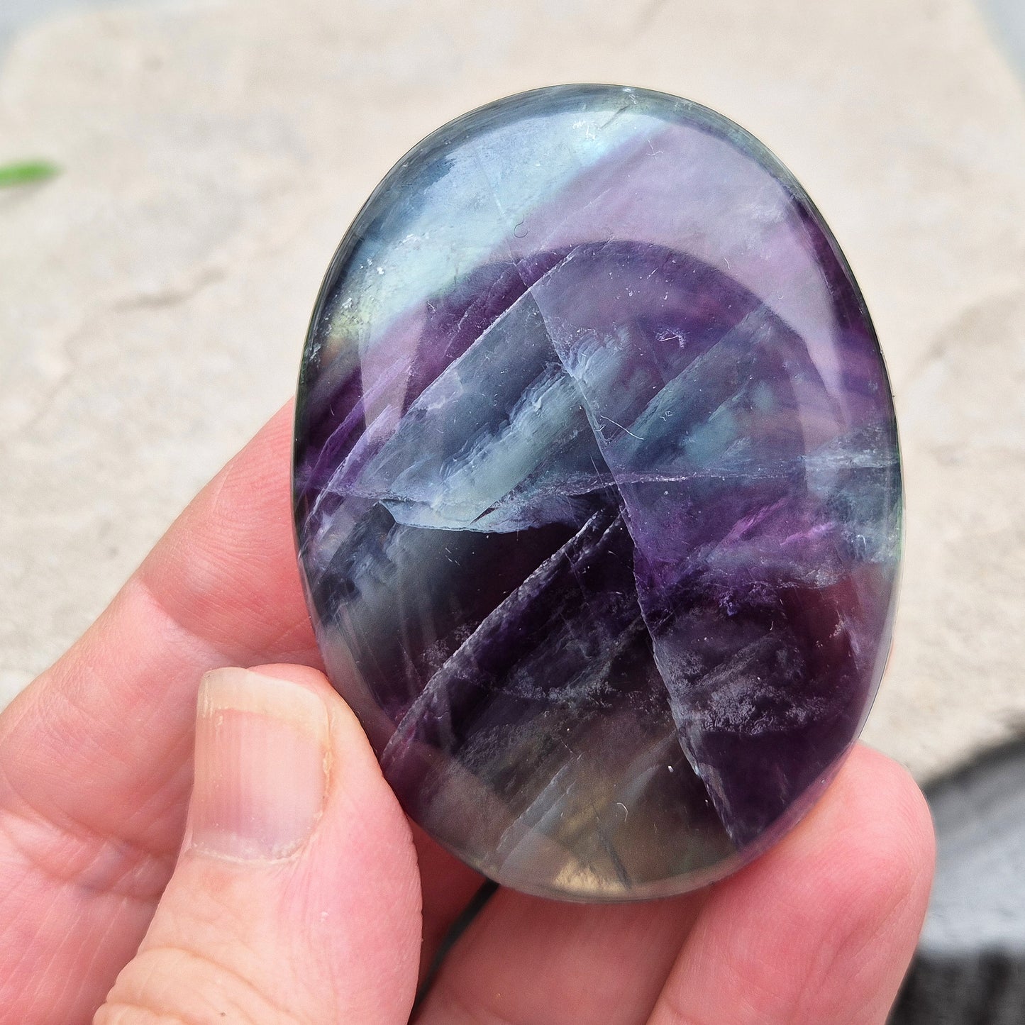 Rainbow Fluorite palm stone for focus and balance. Polished banded crystal to calm the mind, support clear thinking and ease overwhelm.