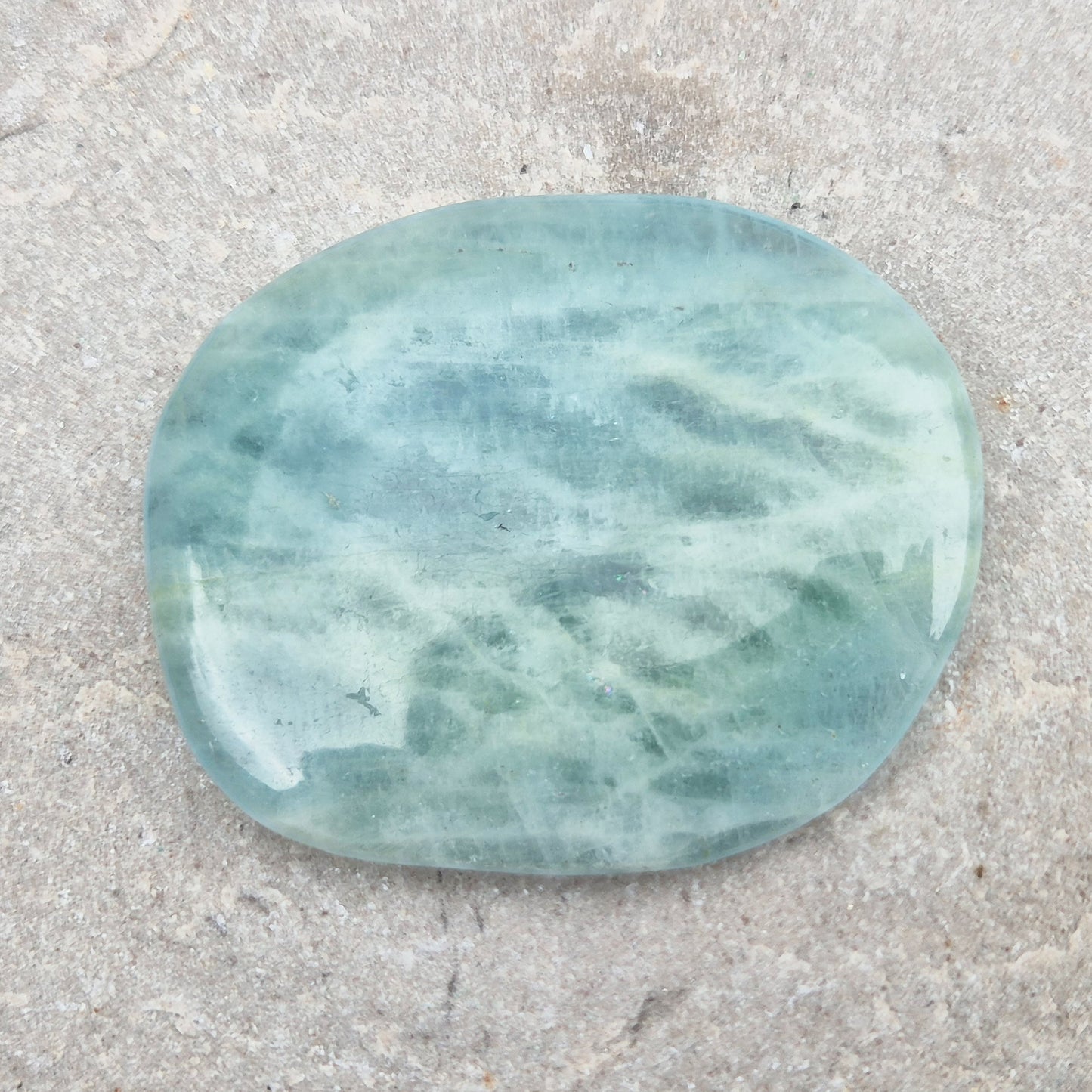 Shop polished Aquamarine palm stones — calming, water-toned crystals known for supporting clear communication. A thoughtful gift for anyone facing a stressful time.