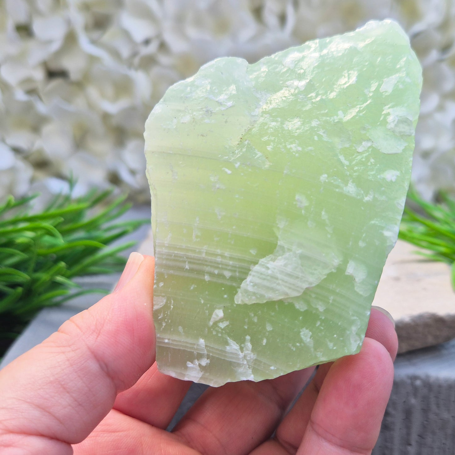 This natural self-standing Pistachio Calcite crystal comes from Pakistan and shows soft pale green to pistachio tones. This variety of Green Calcite gets its colouring from trace minerals embedded as the calcite formed.
