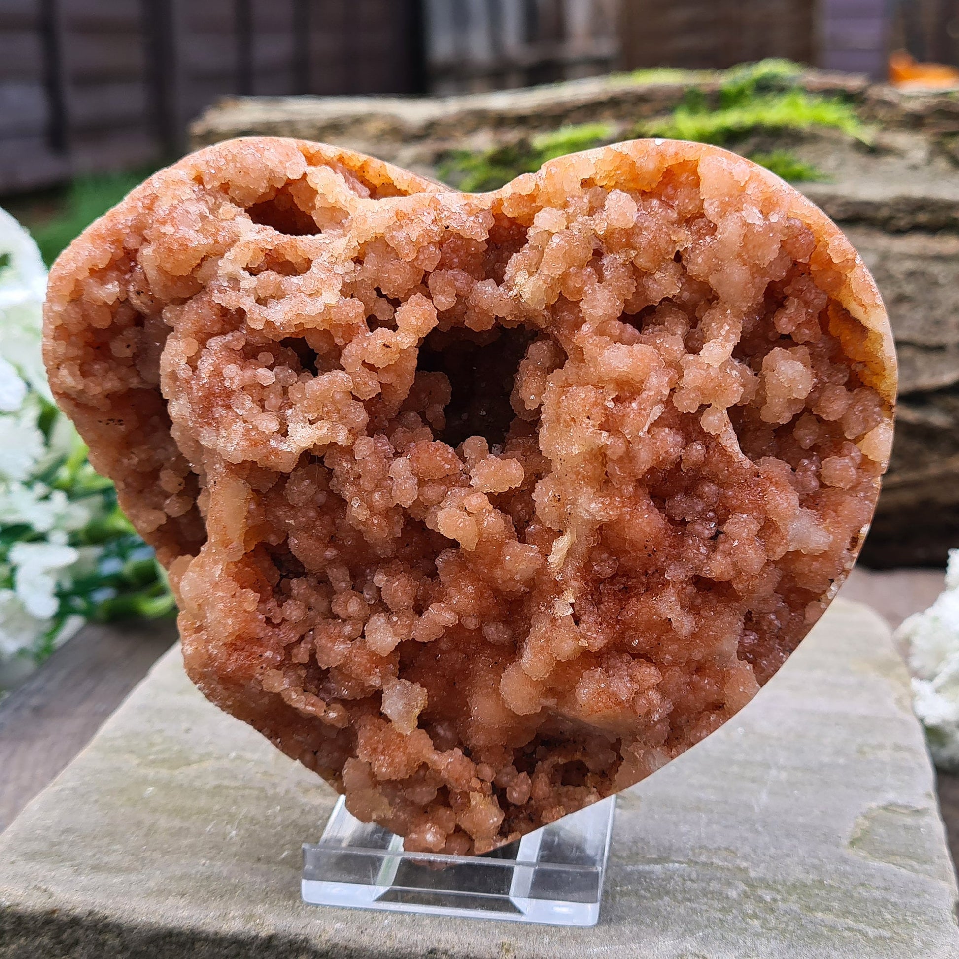 This striking Red Amethyst Heart showcases natural druzy crystal formations in shades of dusky pink/red. Its polished sides and natural base allow it to sit flat, while the included stand lets you display it upright as a beautiful statement piece.
