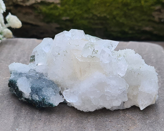Apophyllite Cluster From India. Great quality Apophyllite crystal formations in this cluster, really clear points and a partially exposed cube of Calcite in the middle of the cluster. Also known as a Zeolite.