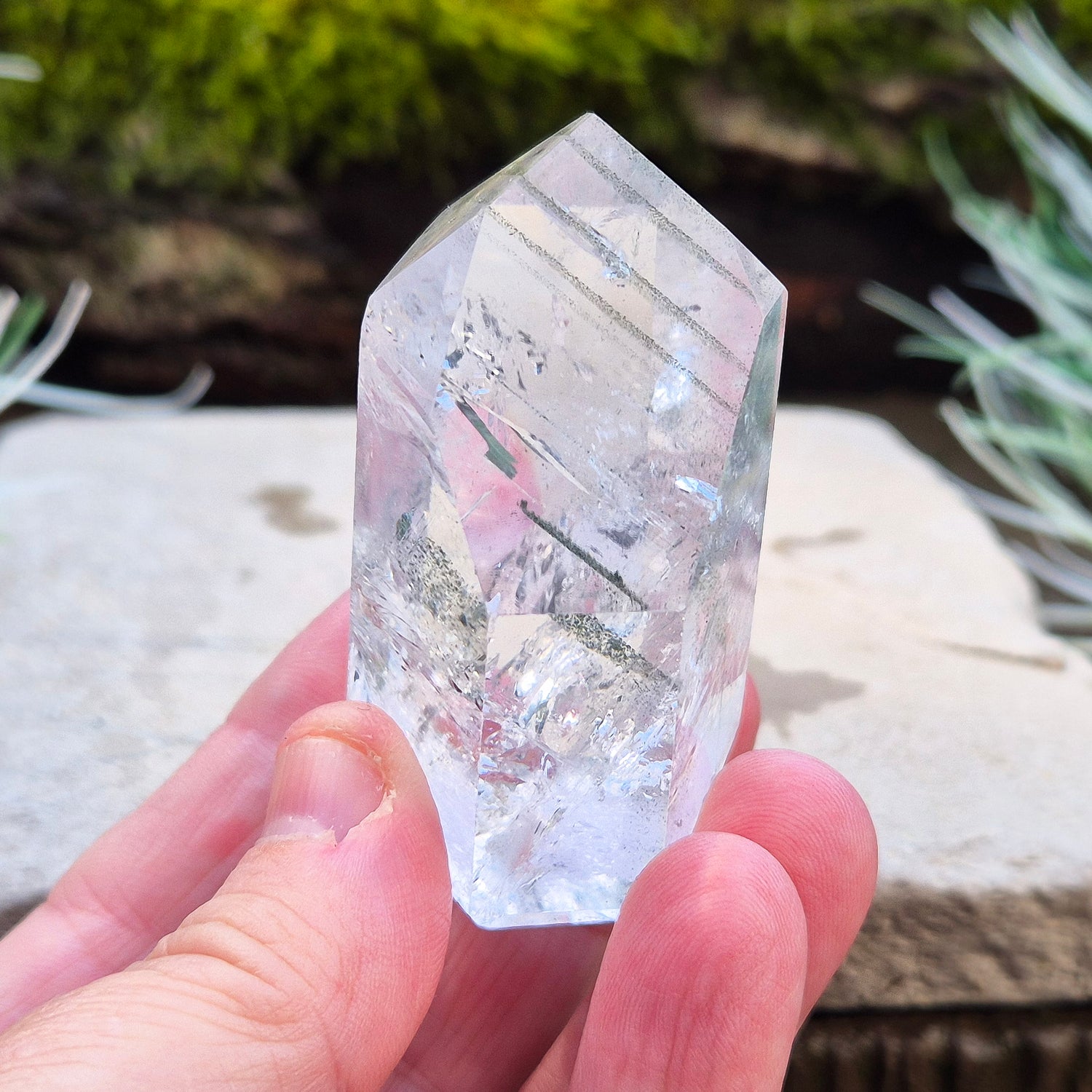 Quartz Crystal Standing Point from Minas Gerais, Brazil. This is a wonderfully clear quartz point with light reflecting inclusions and what looks to be very fine green Chlorite inclusions creating the stripe effects. Super energy coming from this beauty !