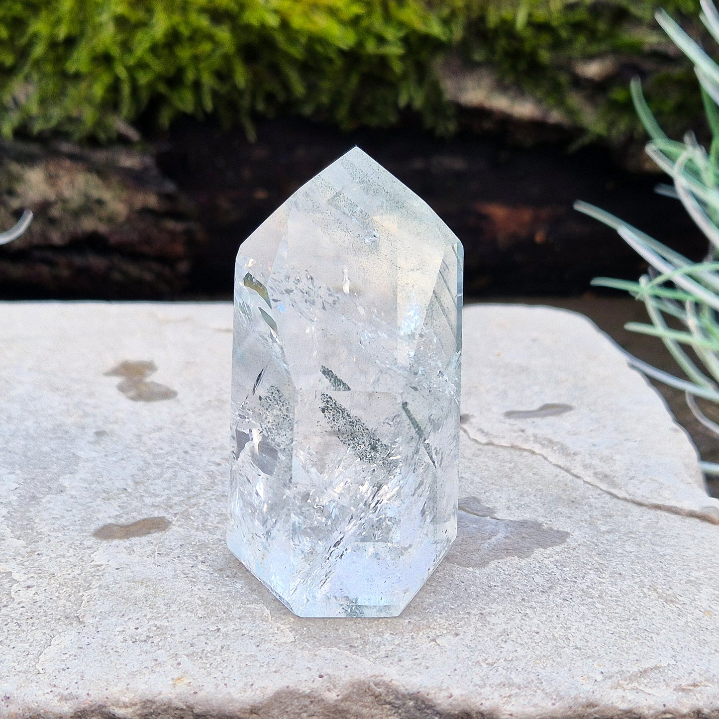 Quartz Crystal Standing Point from Minas Gerais, Brazil. This is a wonderfully clear quartz point with light reflecting inclusions and what looks to be very fine green Chlorite inclusions creating the stripe effects. Super energy coming from this beauty !