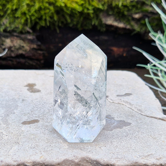 Quartz Crystal Standing Point from Minas Gerais, Brazil. This is a wonderfully clear quartz point with light reflecting inclusions and what looks to be very fine green Chlorite inclusions creating the stripe effects. Super energy coming from this beauty !