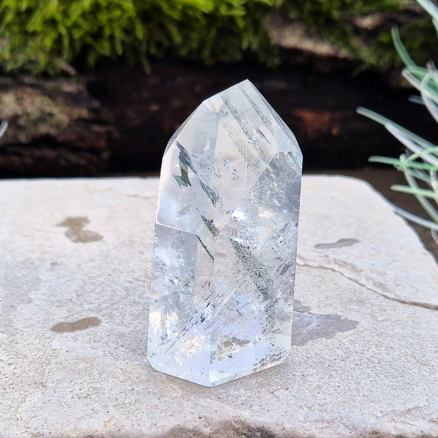 Quartz Crystal Standing Point from Minas Gerais, Brazil. This is a wonderfully clear quartz point with light reflecting inclusions and what looks to be very fine green Chlorite inclusions creating the stripe effects. Super energy coming from this beauty !