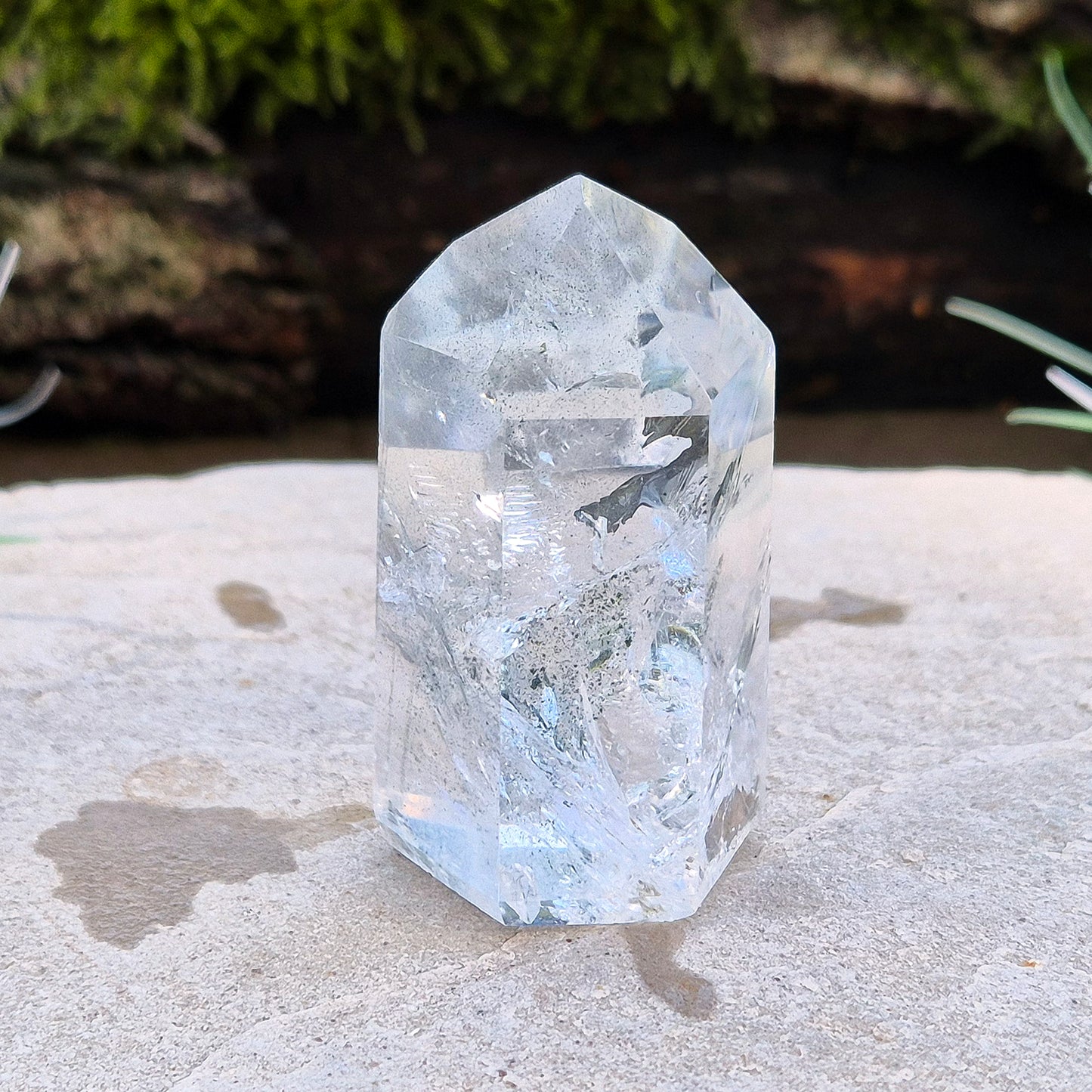 Quartz Crystal Standing Point from Minas Gerais, Brazil. This is a wonderfully clear quartz point with light reflecting inclusions and what looks to be very fine green Chlorite inclusions creating the stripe effects. Super energy coming from this beauty !