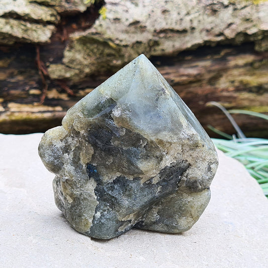 Labradorite crystal standing point with a polished tip and base. The natural sides are smoothed, and the piece displays blue flashes visible in certain light and angles. Also known as Spectrolite.