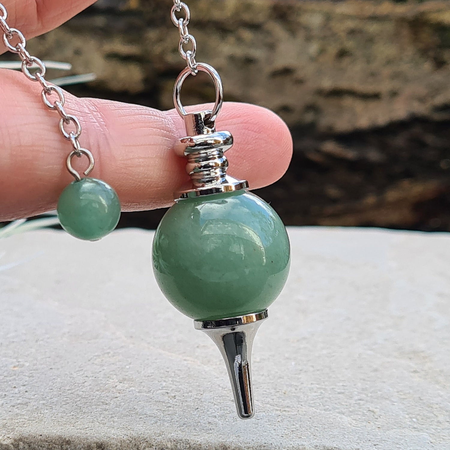 Green Aventurine Crystal Pendulum. comprises of a Green Aventurine crystal ball and metal tip pendulum fixing and a green bead at the end of the chain. Comes in a box or pouch.