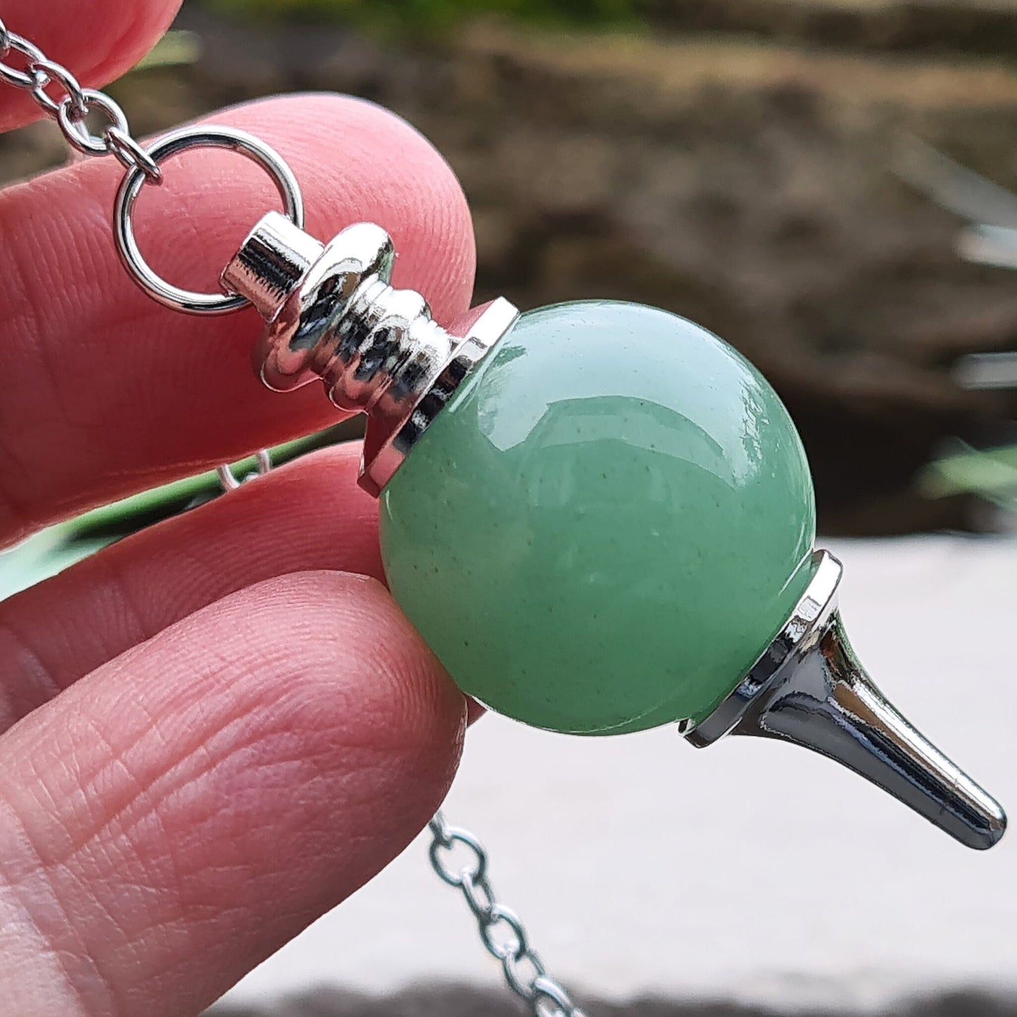 Green Aventurine Crystal Pendulum. comprises of a Green Aventurine crystal ball and metal tip pendulum fixing and a green bead at the end of the chain. Comes in a box or pouch.