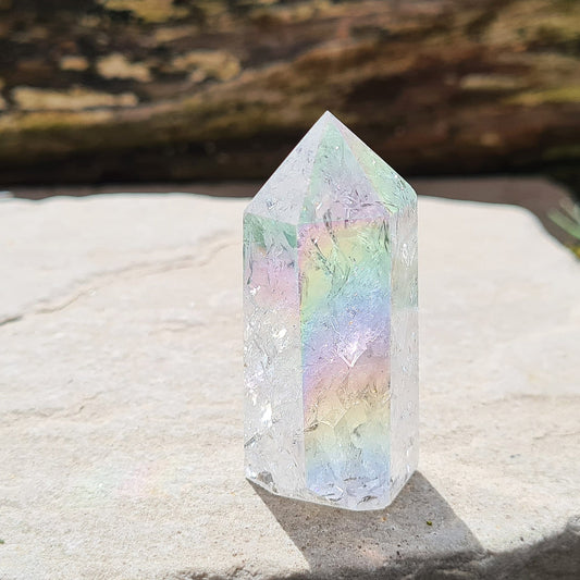 Aura Fire and Ice Quartz Polished Standing Point, also known as Unicorn Horns, Angel Aura Fire and Ice, and Rainbow Quartz. This high-vibration crystal features beautiful rainbows and inclusions, created by heating and rapidly cooling quartz, resulting in a sparkling light-filled appearance.