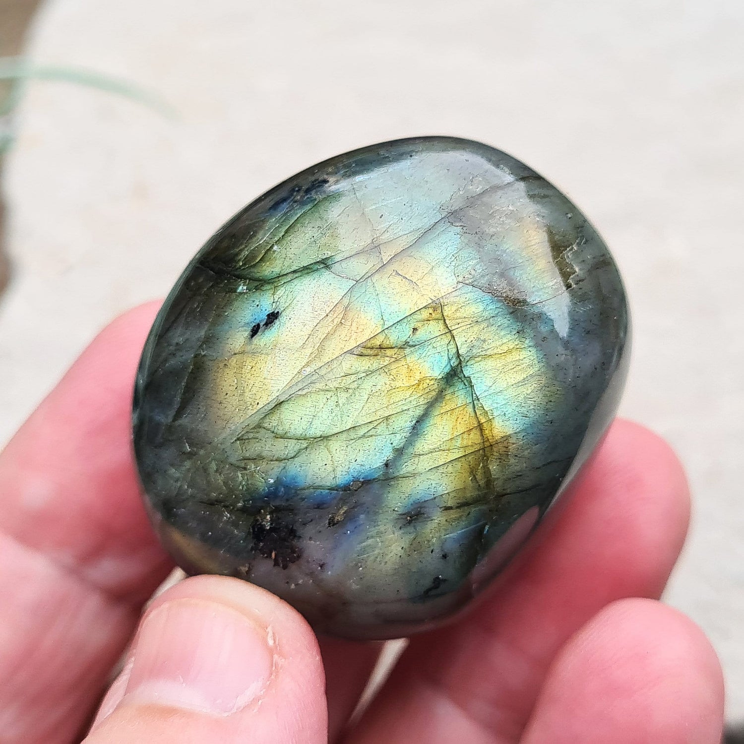 Polished Labradorite Crystal Pebble from Madagascar, also known as Spectrolite. Nice flashes of green, gold, and indigo blue colour in the light.