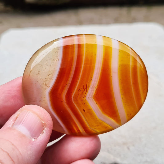 Carnelian Crystal Palm Stone. From Madagascar. This palm stone has a wonderful orange and white banding and colouring.