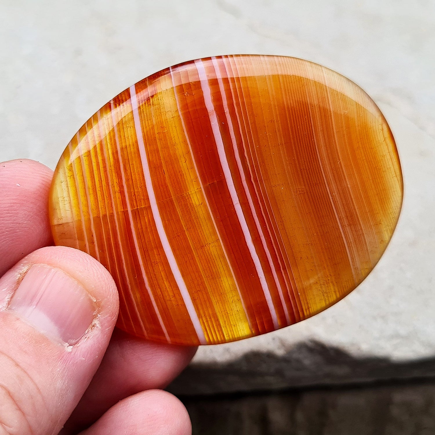 Carnelian Crystal Palm Stone. From Madagascar. This palm stone has a wonderful orange banding and colouring.