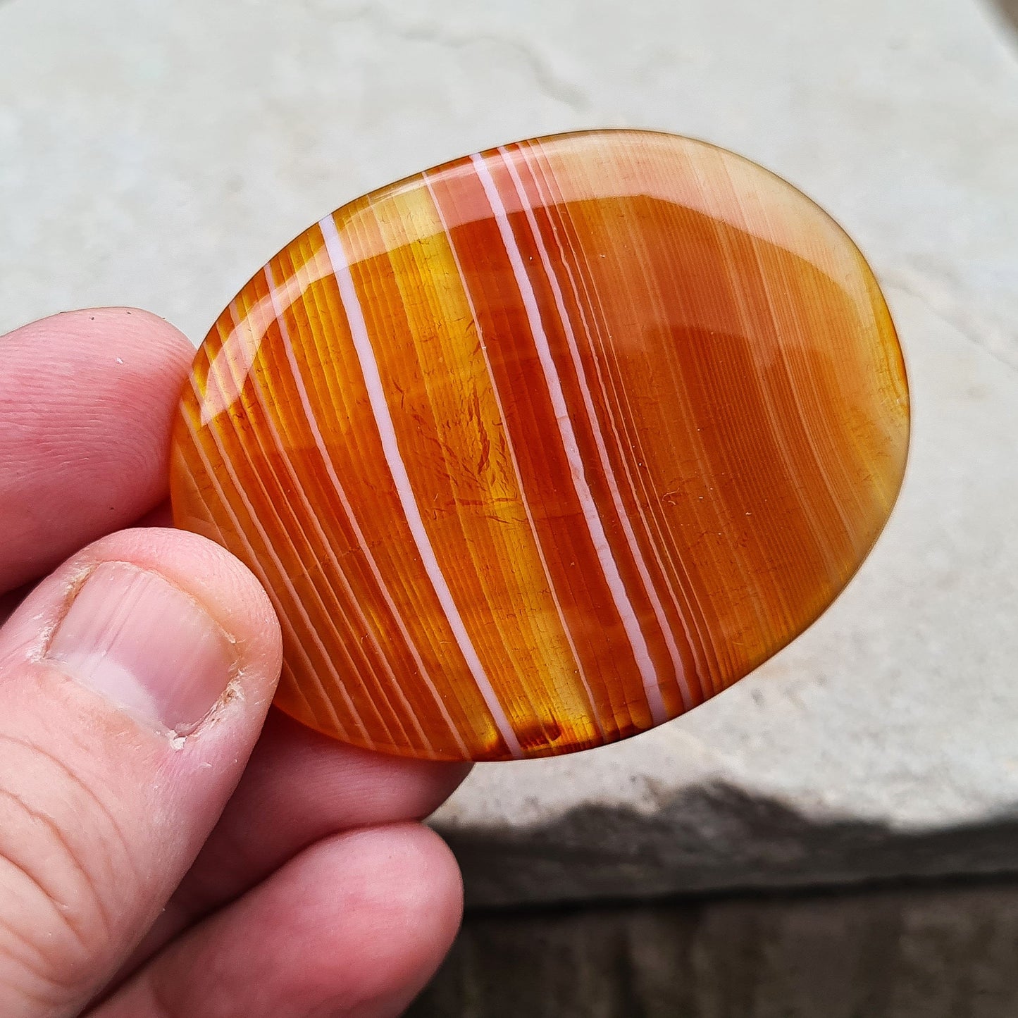 Carnelian Crystal Palm Stone. From Madagascar. This palm stone has a wonderful orange banding and colouring.