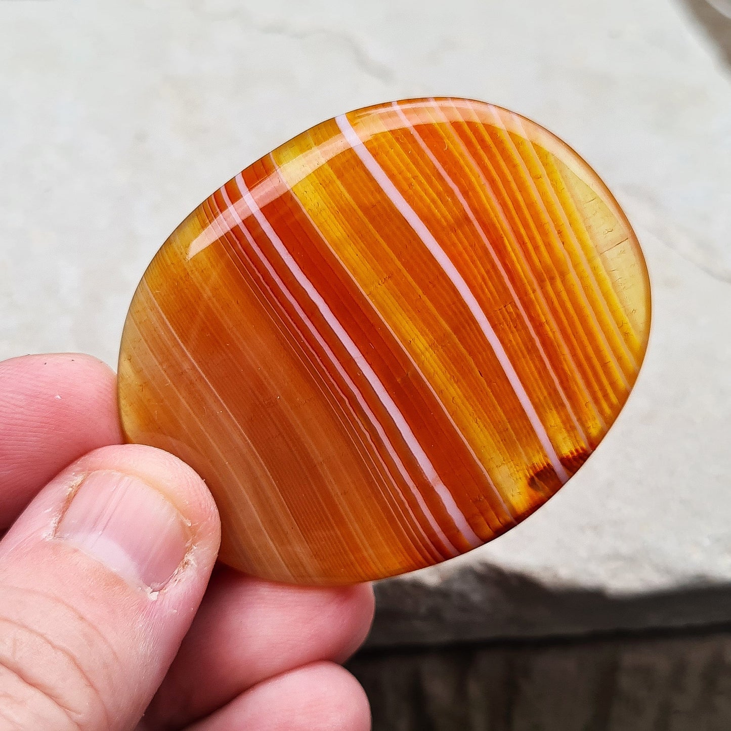 Carnelian Crystal Palm Stone. From Madagascar. This palm stone has a wonderful orange banding and colouring.