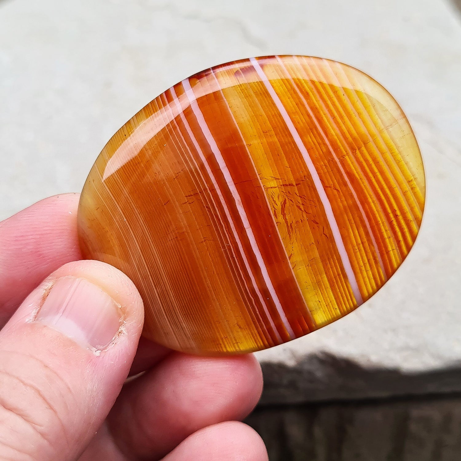 Carnelian Crystal Palm Stone. From Madagascar. This palm stone has a wonderful orange banding and colouring.