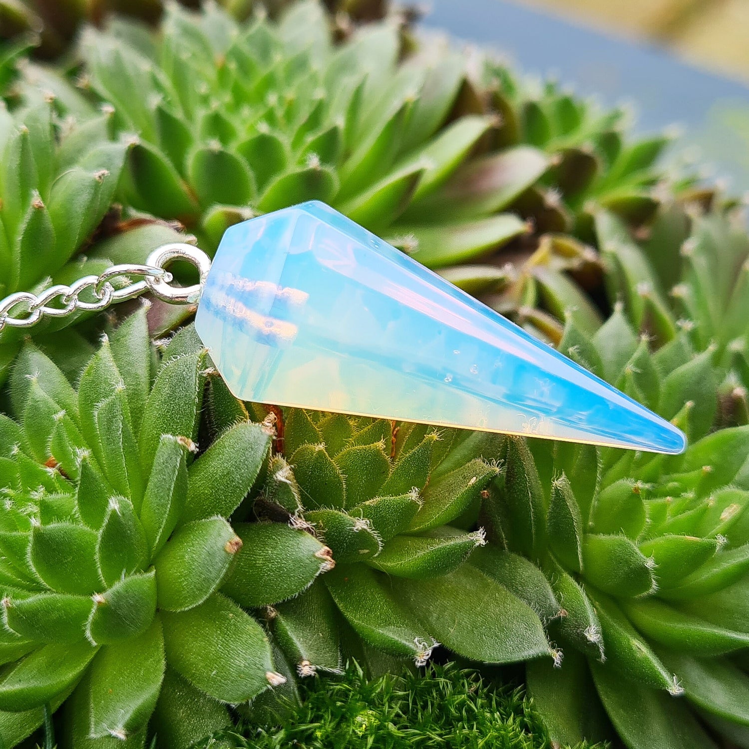 Opalite Crystal Pendulum, at end of the chain is a silver ring. All pendulums will come with a box or organza pouch to keep it in.