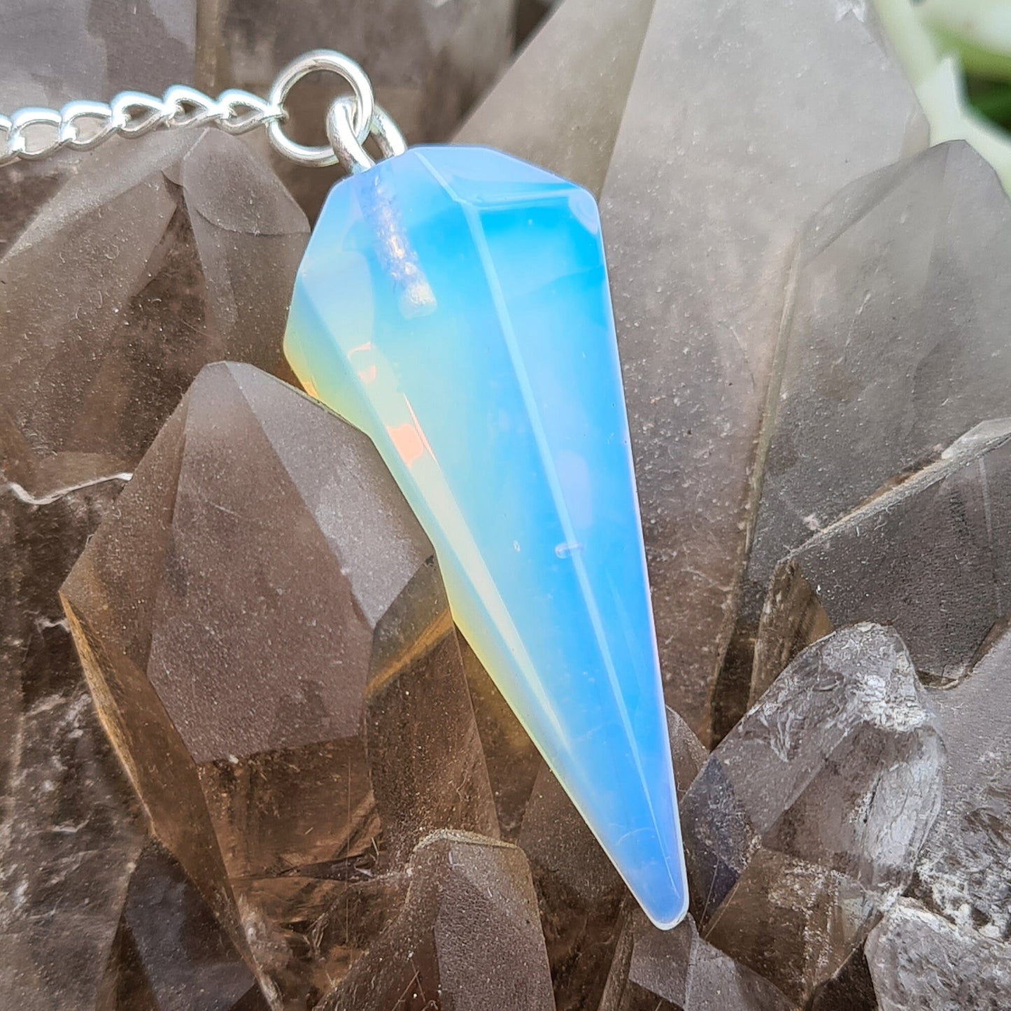 Opalite Crystal Pendulum, at end of the chain is a silver ring. All pendulums will come with a box or organza pouch to keep it in.