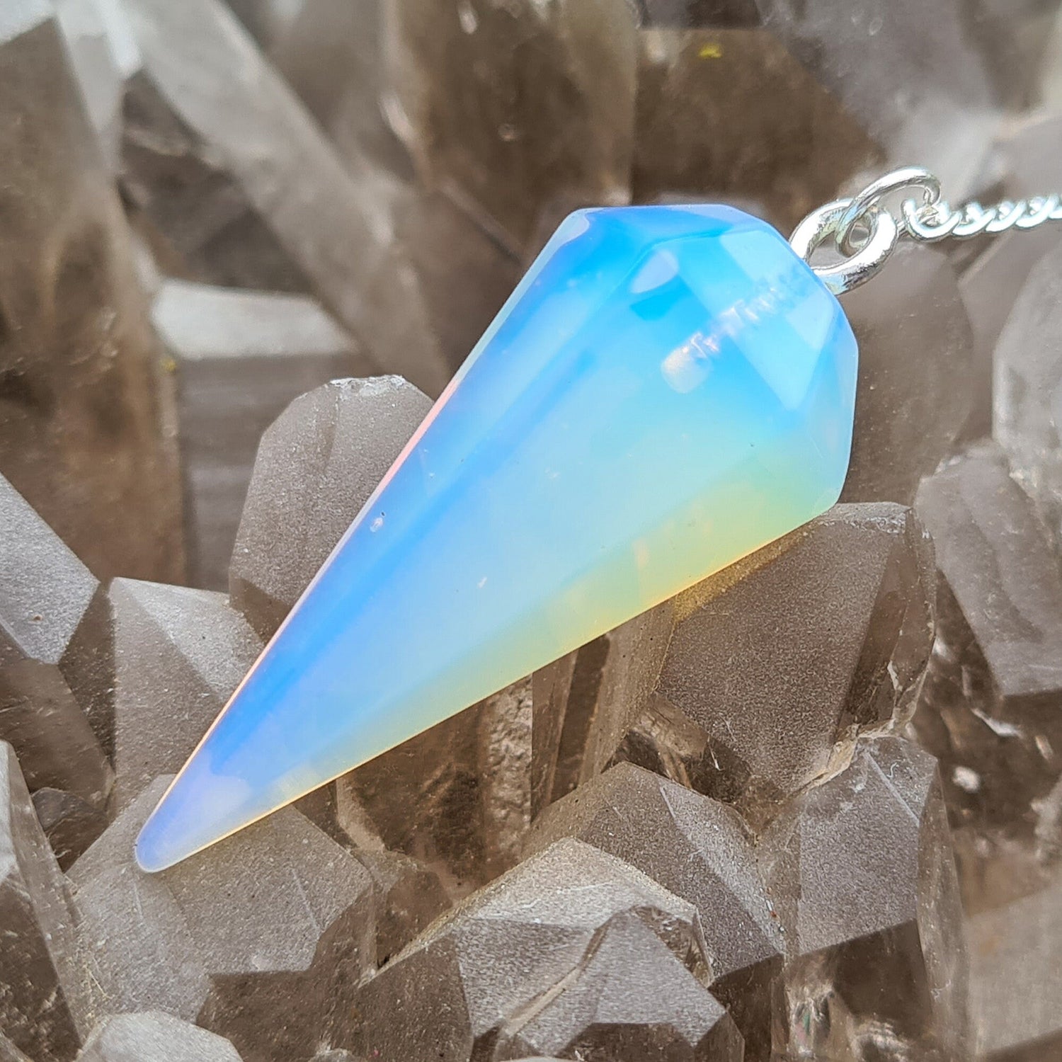 Opalite Crystal Pendulum, at end of the chain is a silver ring. All pendulums will come with a box or organza pouch to keep it in.