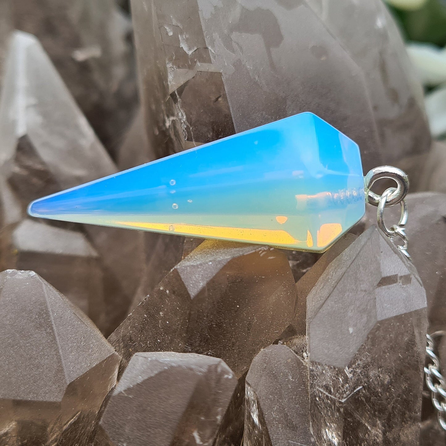 Opalite Crystal Pendulum, at end of the chain is a silver ring. All pendulums will come with a box or organza pouch to keep it in.