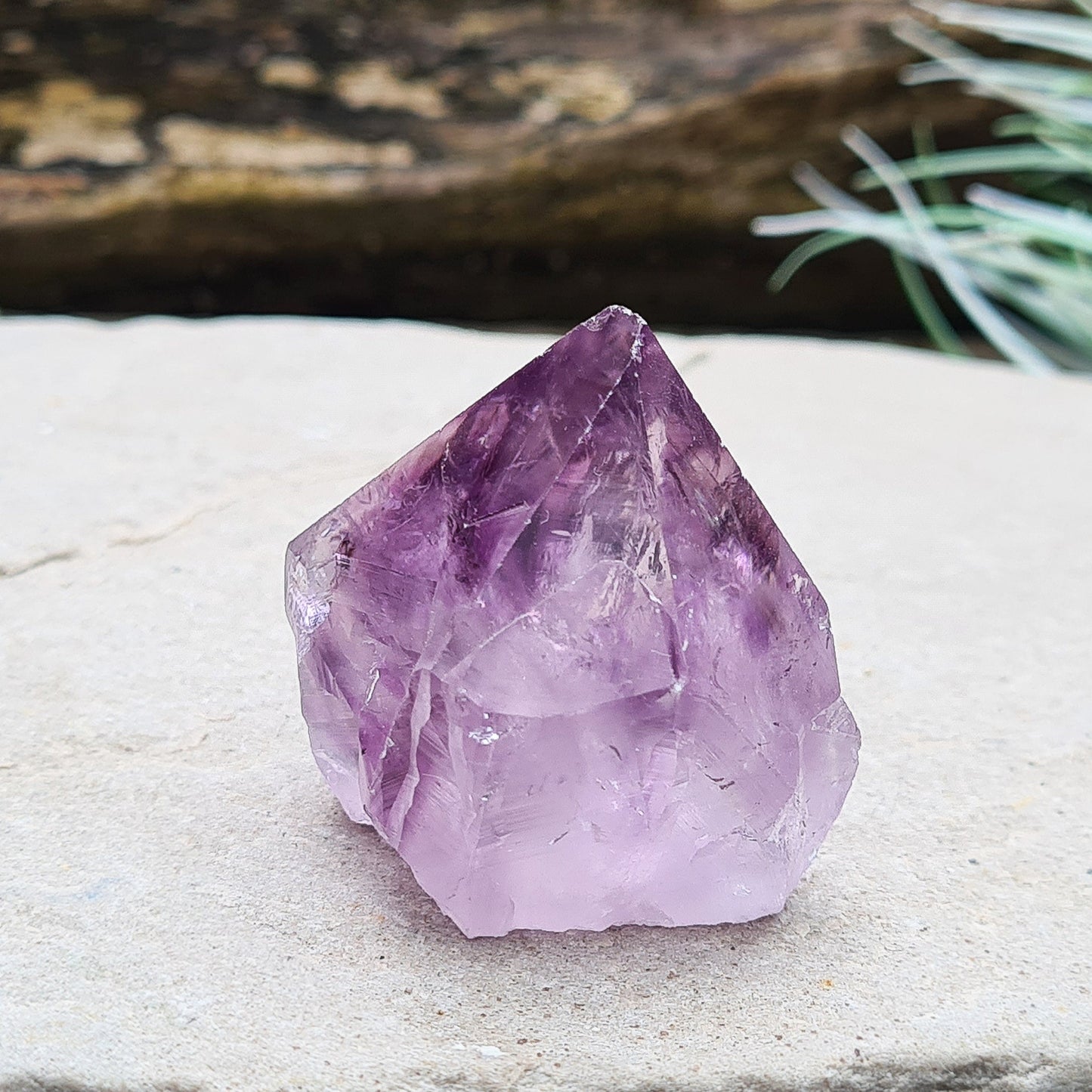 Amethyst crystal standing point from Brazil with a polished tip and a flat cut base. Features beautiful translucent purple coloring, while the remaining surface is left natural.