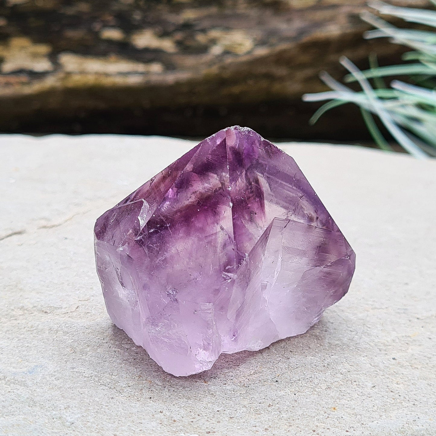 Amethyst crystal standing point from Brazil with a polished tip and a flat cut base. Features beautiful translucent purple coloring, while the remaining surface is left natural.