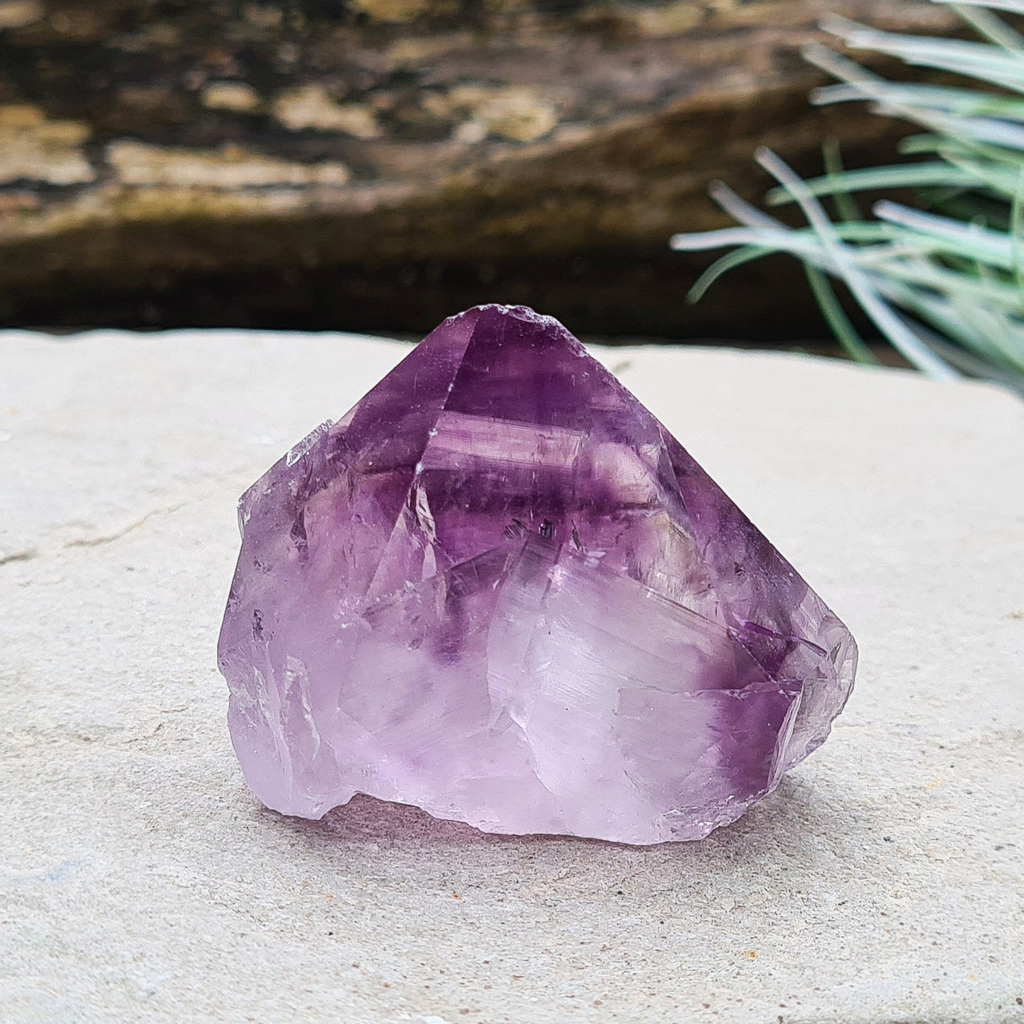 Amethyst crystal standing point from Brazil with a polished tip and a flat cut base. Features beautiful translucent purple coloring, while the remaining surface is left natural.