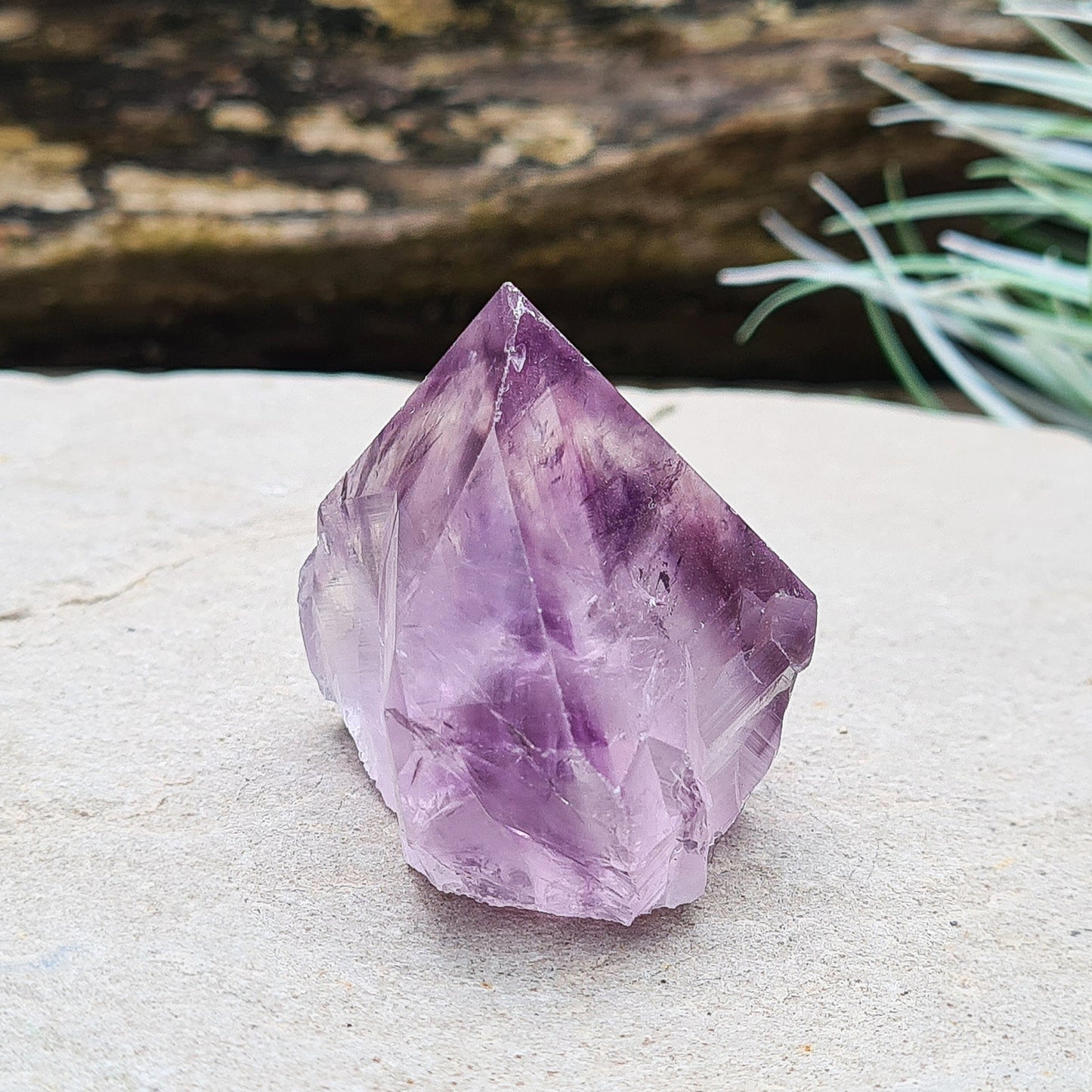 Amethyst crystal standing point from Brazil with a polished tip and a flat cut base. Features beautiful translucent purple coloring, while the remaining surface is left natural.