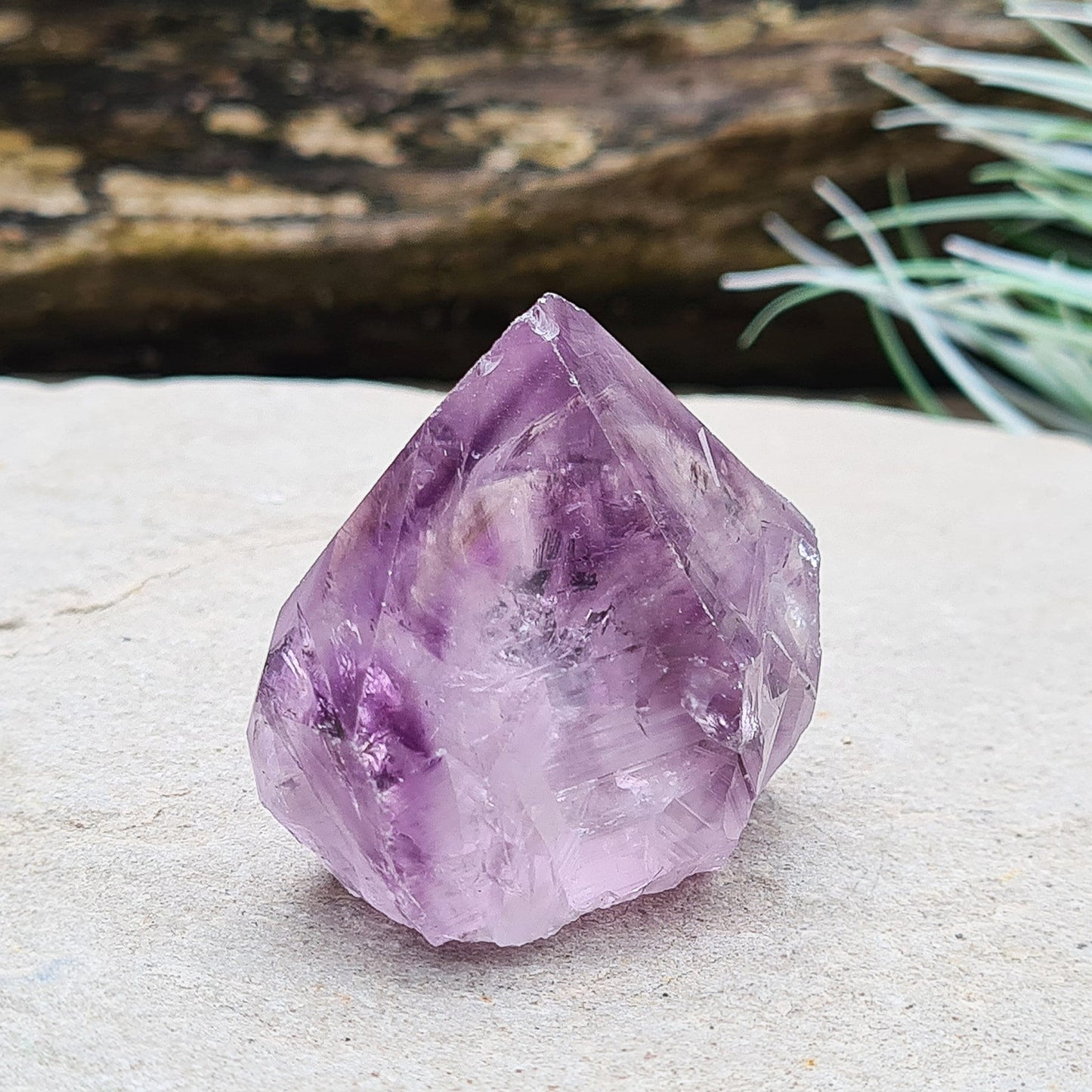 Amethyst crystal standing point from Brazil with a polished tip and a flat cut base. Features beautiful translucent purple coloring, while the remaining surface is left natural.