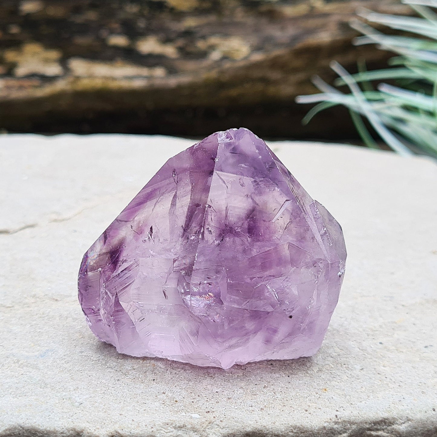 Amethyst crystal standing point from Brazil with a polished tip and a flat cut base. Features beautiful translucent purple coloring, while the remaining surface is left natural.