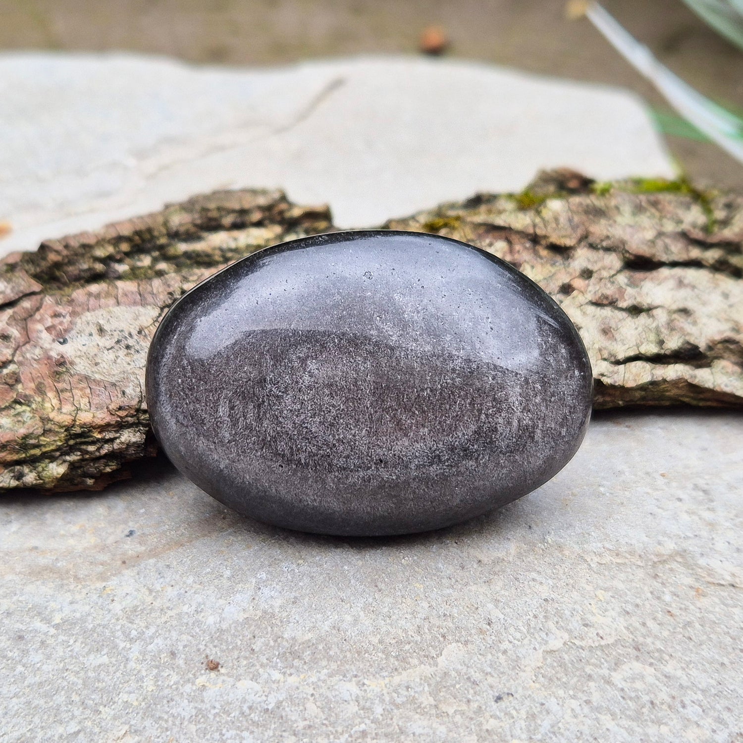 Silver Sheen Obsidian Crystal Palm Stone. Silver sheen obsidian is a type of volcanic glass which is primarily black or dark grey and has a distinctive silvery or metallic sheen on its surface