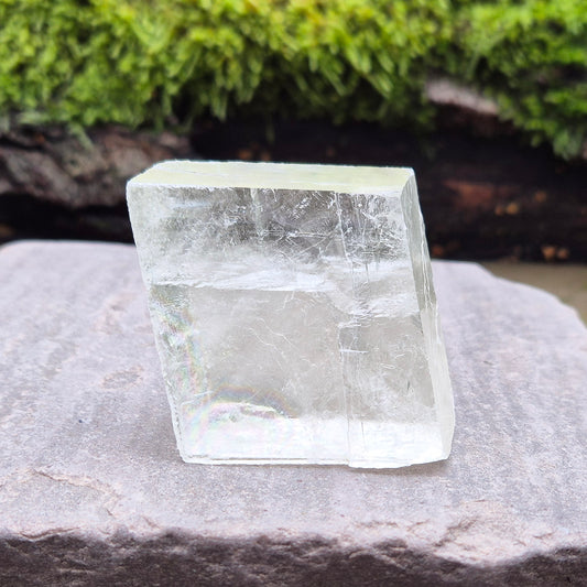 Polished Optical Calcite Crystal with Rainbows, rhomboid shape, yellowish tint, also known as Iceland Spar or Fairy Glass with unique optical properties.