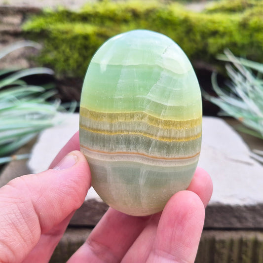 Banded Pistachio Calcite Crystal Palm Stone. From the Khyber Pakhtunkhwa province of Pakistan.