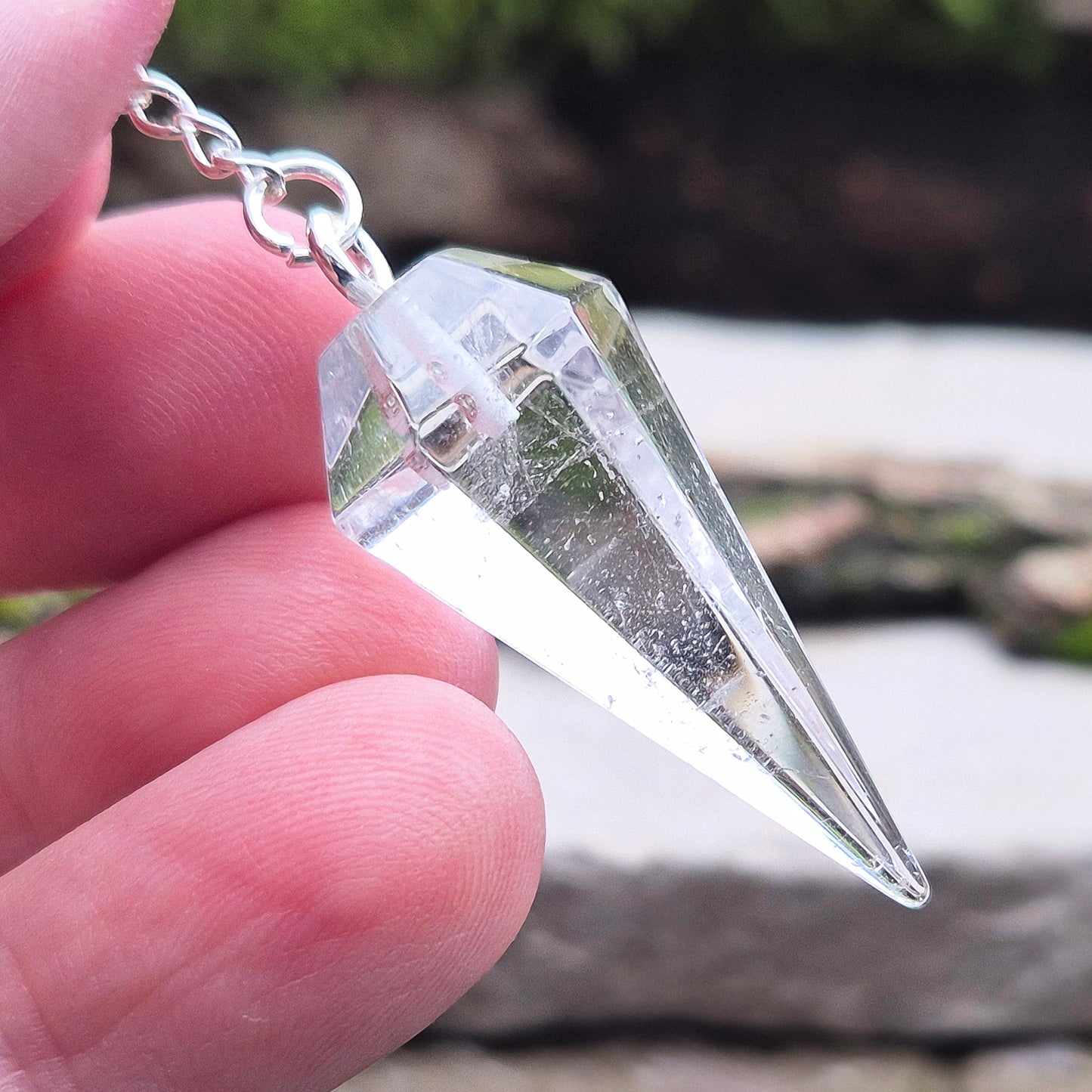 Clear Quartz Crystal Pendulum for dowsing and energy work. Comes in a box or pouch for easy storage. The chain features a silver ring for a comfortable grip.