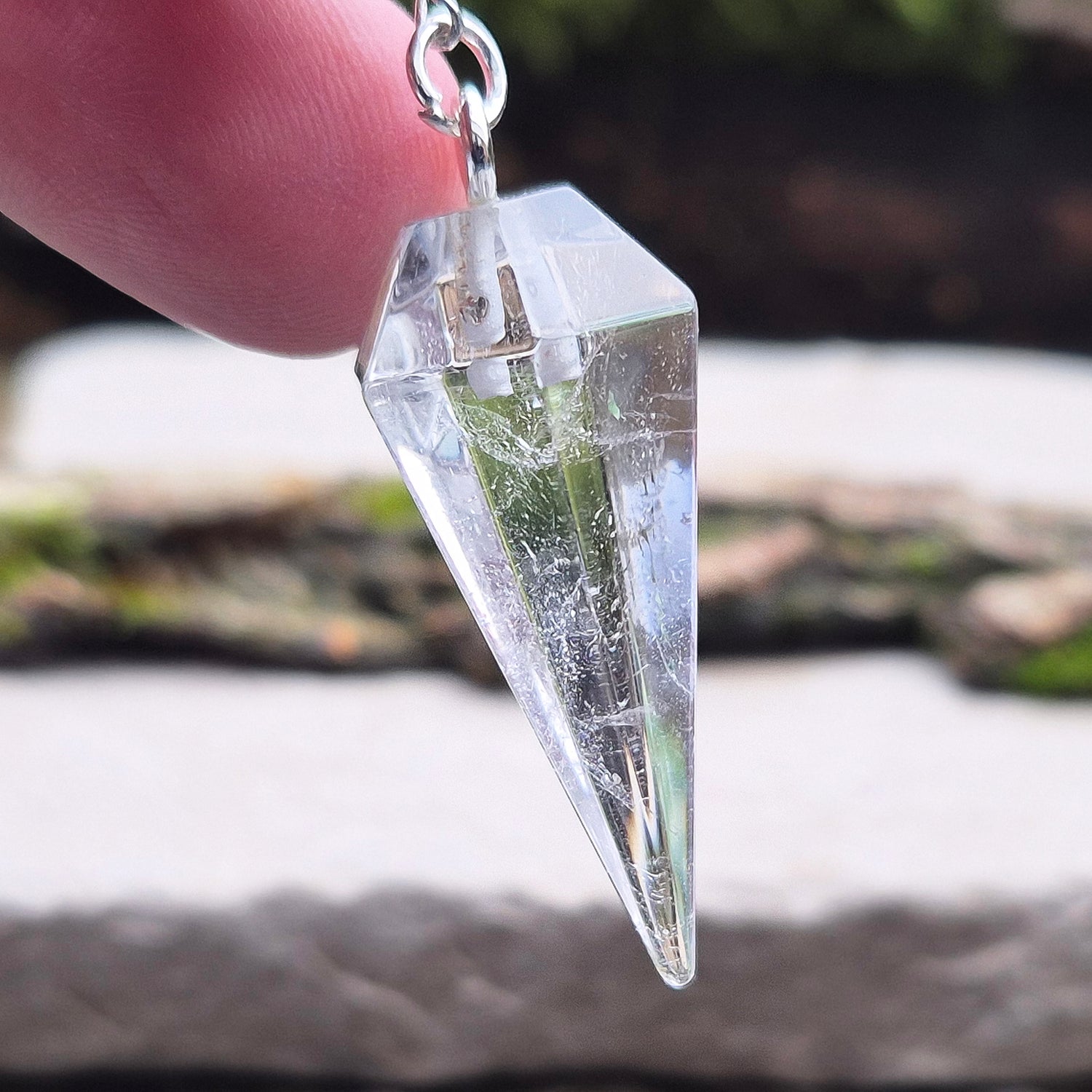 Clear Quartz Crystal Pendulum for dowsing and energy work. Comes in a box or pouch for easy storage. The chain features a silver ring for a comfortable grip.