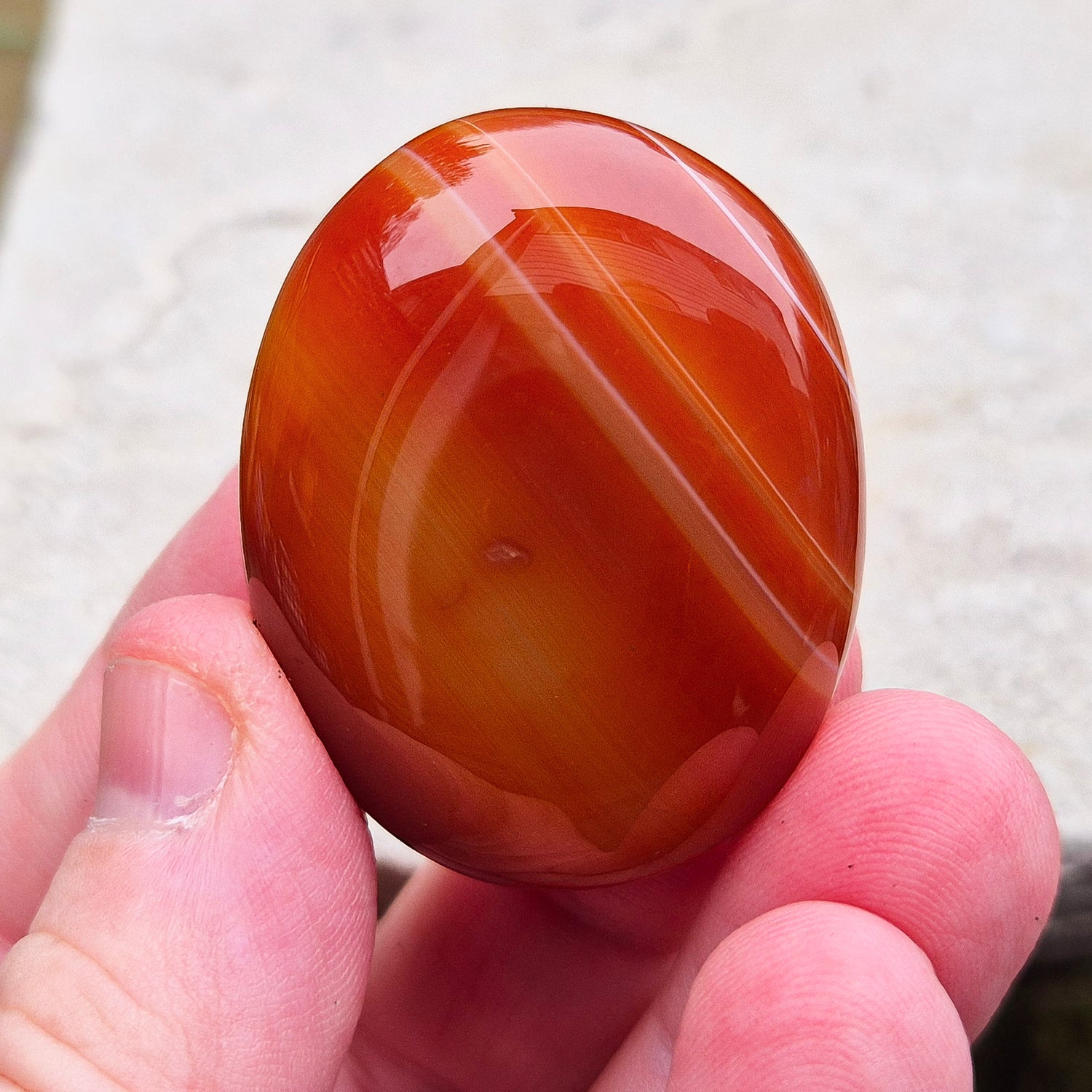 Carnelian Crystal Palm Stone. From Madagascar. This palm stone has a wonderful orange colour and some banding.