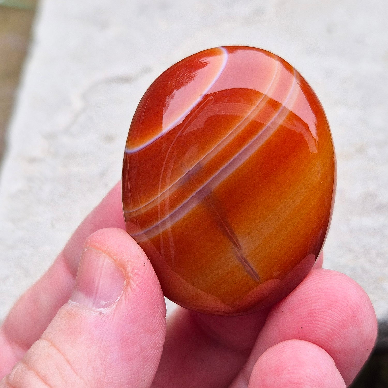 Carnelian Crystal Palm Stone. From Madagascar. This palm stone has a wonderful orange colour and some banding.