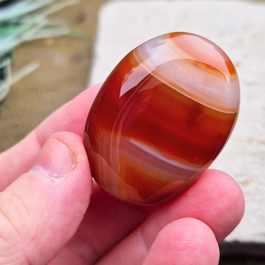 Carnelian Crystal Palm Stone. From Madagascar. This palm stone has a wonderful orange and white banded colouring.